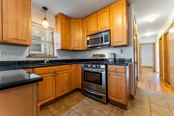 a kitchen with stainless steel appliances granite countertop a stove a sink and a microwave