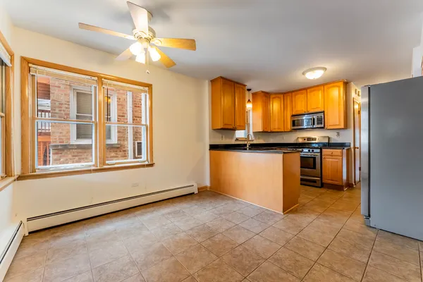 a open kitchen with stainless steel appliances granite countertop a refrigerator and a stove top oven