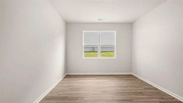 a view of an empty room with wooden floor