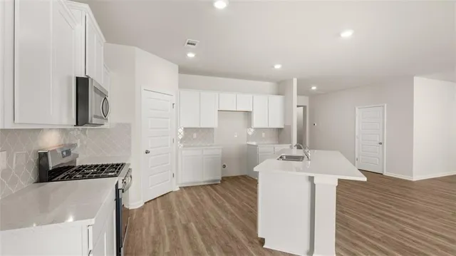 a kitchen with a sink cabinets and wooden floor