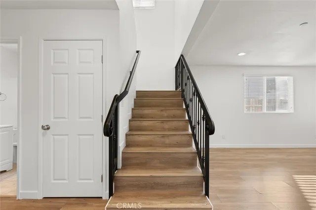 a view of staircase with white walls and railing