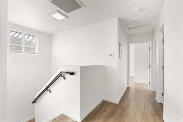 a view of hallway with stairs and wooden floor