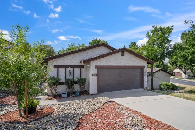 a view of a house with a yard and potted plants