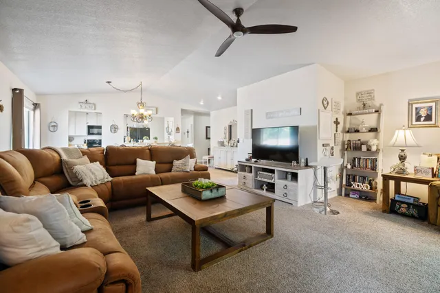 a living room with furniture kitchen view and a window