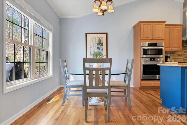 a view of a dining room with furniture a chandelier and wooden floor