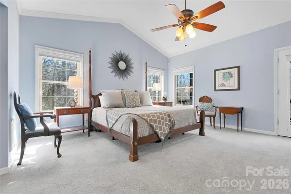 a spacious bedroom with a bed a chandelier and a window
