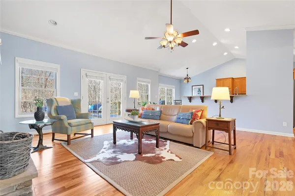 a living room with furniture kitchen view and a large window