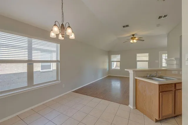 a view of a kitchen with a sink and chandelier