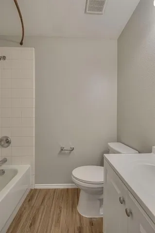a white toilet sitting next to a bath tub