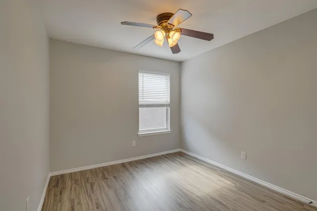 an empty room with a window and a fan