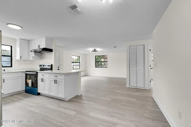 a kitchen with granite countertop a stove a sink and a refrigerator