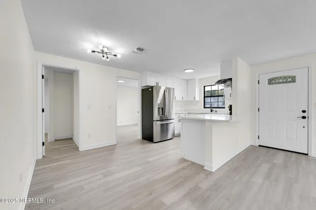 a kitchen with stainless steel appliances a refrigerator and wooden floor