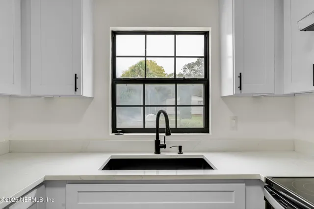 a view of a kitchen counter space a sink and a window