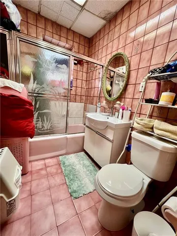 a bathroom with a toilet a sink and mirror