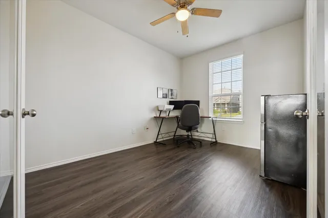 a view of a workspace with wooden floor and a window