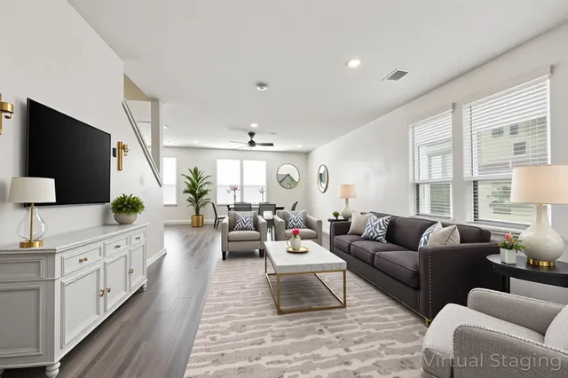 a living room with furniture a large window and a flat screen tv