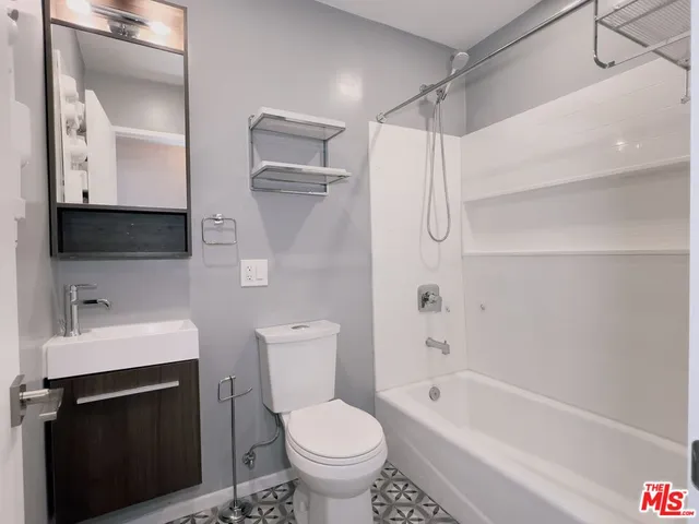 a bathroom with a bathtub toilet sink and mirror
