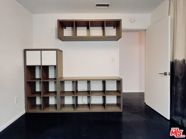a view of a big room with wooden floor and a cabinet