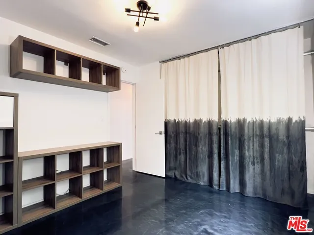 a view of wooden floor and a window in a room