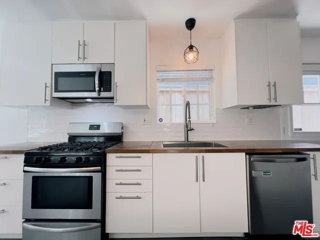 a kitchen with cabinets stainless steel appliances and a counter space