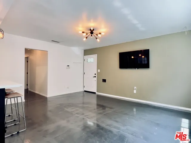 an empty room with windows and a flat screen tv