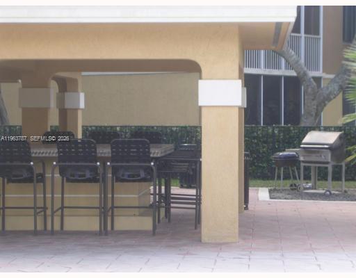4055 West McNab Road, Unit H303 Pompano Beach, FL 33069 - Photo 11 of 12 a view of a patio with table and chairs and potted plants