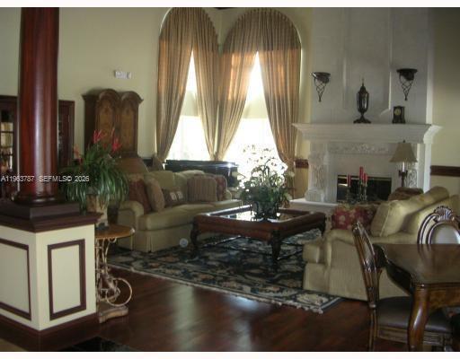 4055 West McNab Road, Unit H303 Pompano Beach, FL 33069 - Photo 7 of 12 a living room with fireplace furniture and a large window