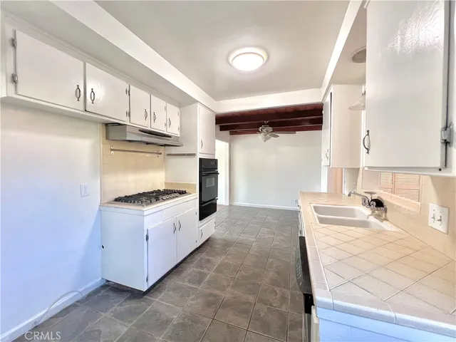 a kitchen with granite countertop a sink and a stove top oven