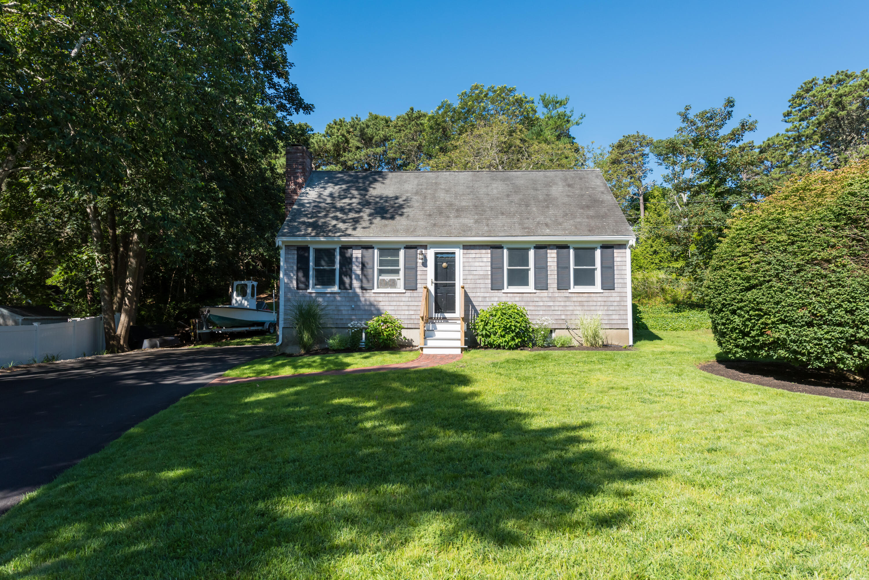 a front view of a house with a yard and trees