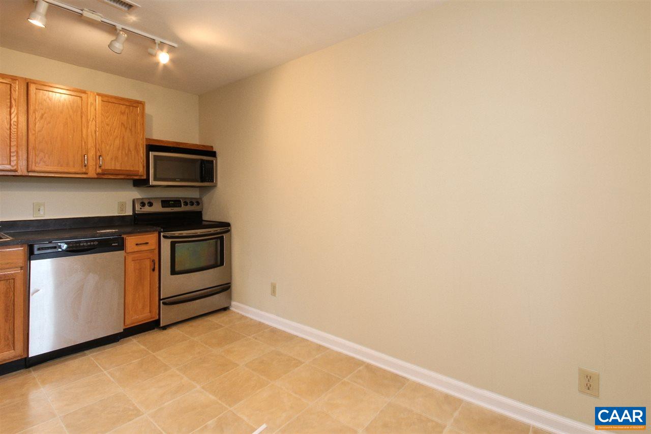 1254 Villa Lane, Unit A Charlottesville, VA 22903 - Photo 5 of 10 a kitchen with granite countertop a stove top oven microwave and cabinets