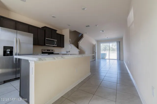 a kitchen with kitchen island granite countertop a sink stainless steel appliances and cabinets