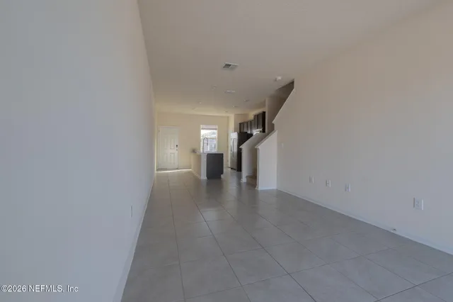 a view of a hallway with wooden floor and a cabinet