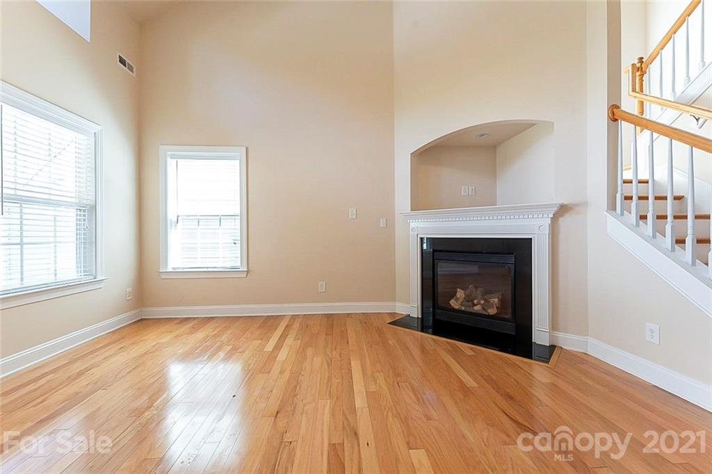 78067 Rillstone Drive Lancaster, SC 29720 - Photo 3 of 14 an empty room with windows a fireplace and wooden floor