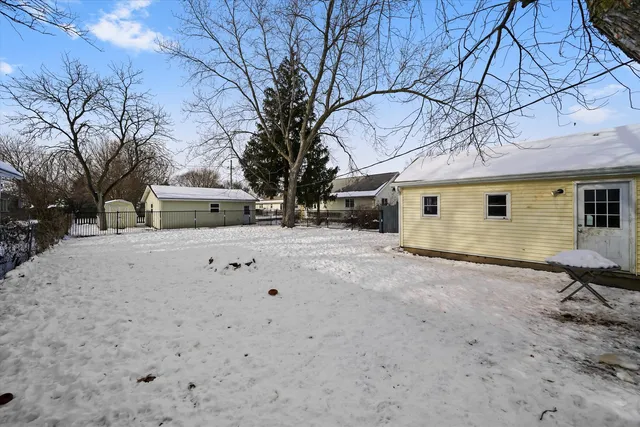 a view of white house with a yard covered in snow
