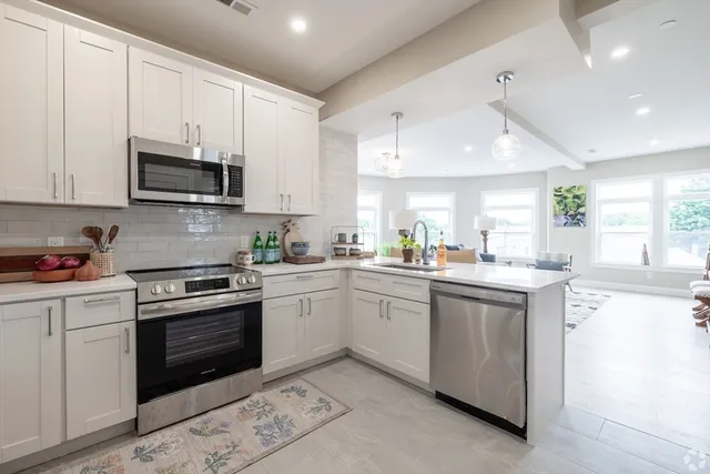 a kitchen with granite countertop white cabinets and white appliances
