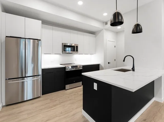 a kitchen with a sink stainless steel appliances and refrigerator