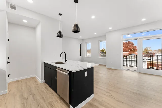 a view of a kitchen with a sink and wooden floor