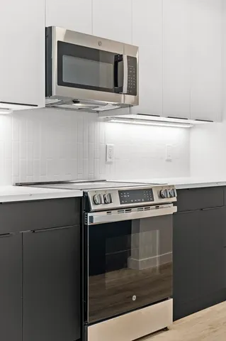 a kitchen with stainless steel appliances granite countertop a stove a microwave and a sink