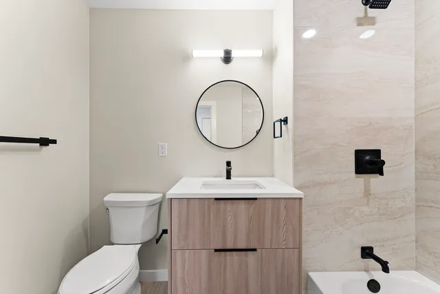 a bathroom with a toilet a sink and mirror