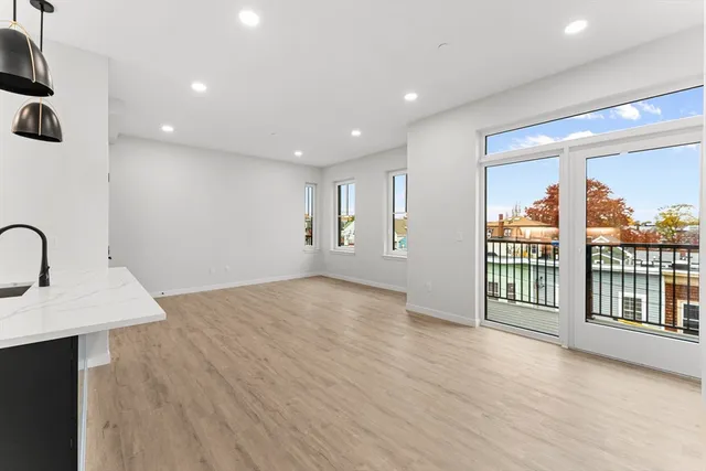 a view of a big room with wooden floor and windows