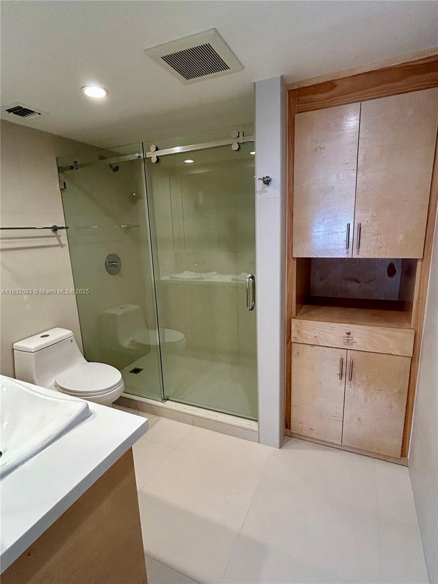 5415 Collins Avenue, Unit 302 Miami Beach, FL 33140 - Photo 17 of 33 a bathroom with a granite countertop sink a mirror and shower
