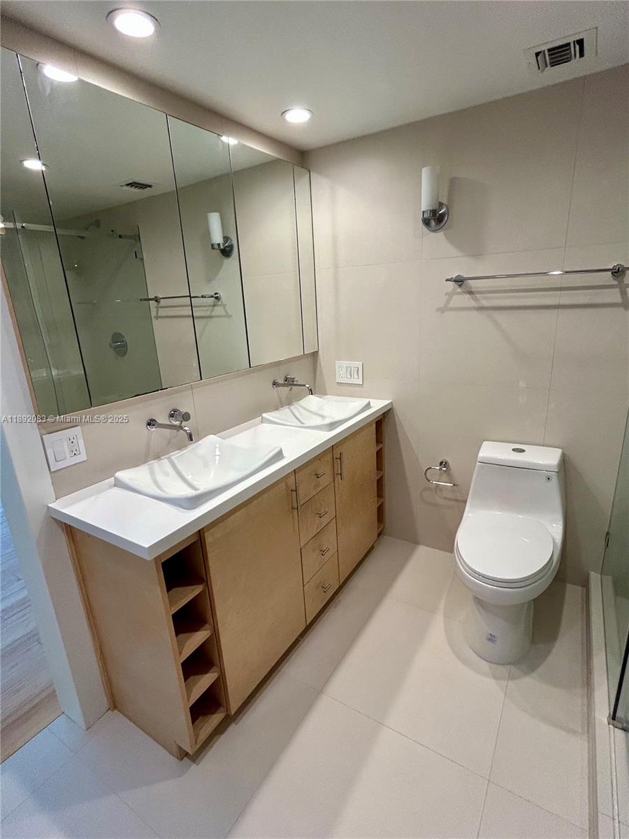 5415 Collins Avenue, Unit 302 Miami Beach, FL 33140 - Photo 18 of 33 a bathroom with a sink toilet and mirror