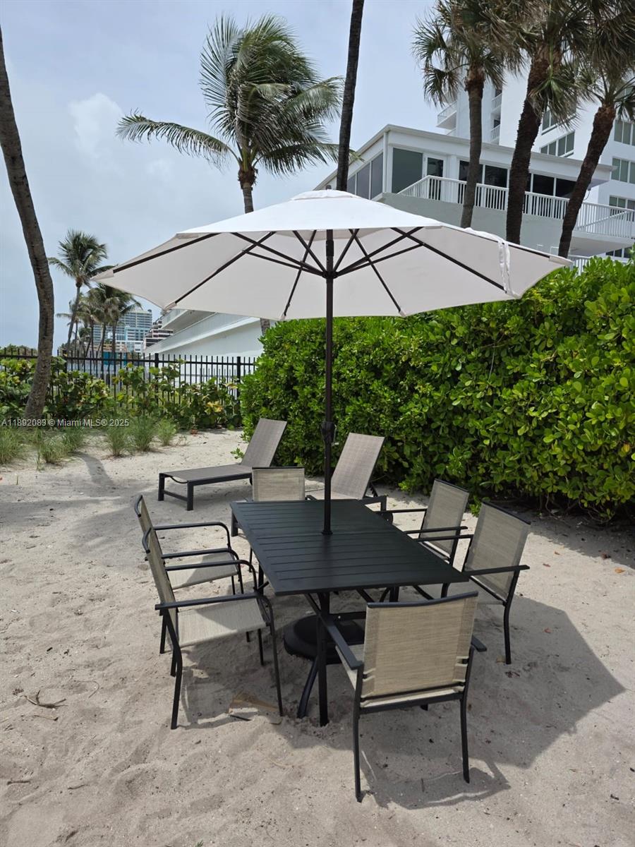 5415 Collins Avenue, Unit 302 Miami Beach, FL 33140 - Photo 31 of 33 a view of a patio with a table and chairs under an umbrella