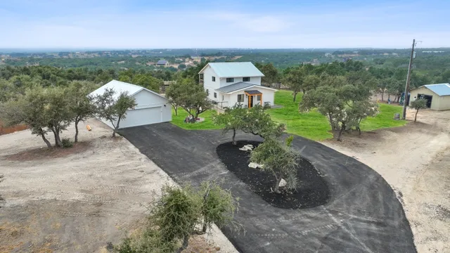 an aerial view of a house with a yard and lake view