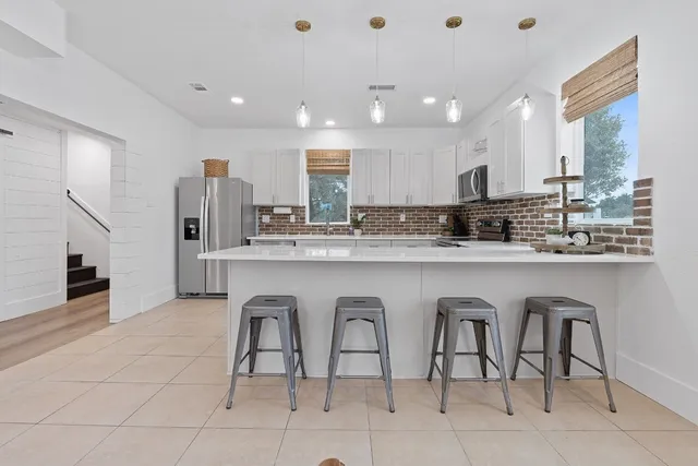 a kitchen with white cabinets sink and stainless steel appliances