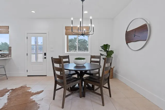 a large kitchen with stainless steel appliances kitchen island granite countertop a table and chairs