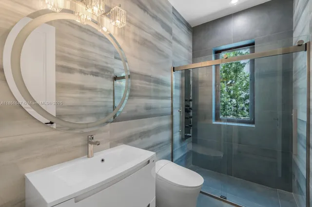 a bathroom with a sink mirror vanity and toilet