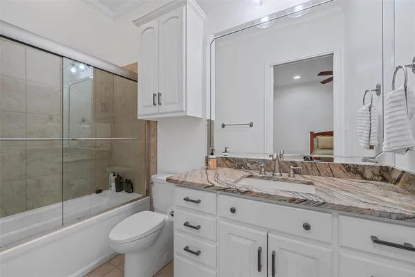 a bathroom with a granite countertop sink a toilet and bathtub