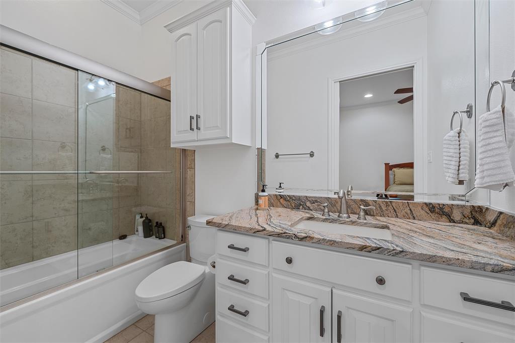1170 Lumkins Road Forreston, TX 76041 - Photo 12 of 40 a bathroom with a granite countertop sink a toilet and bathtub