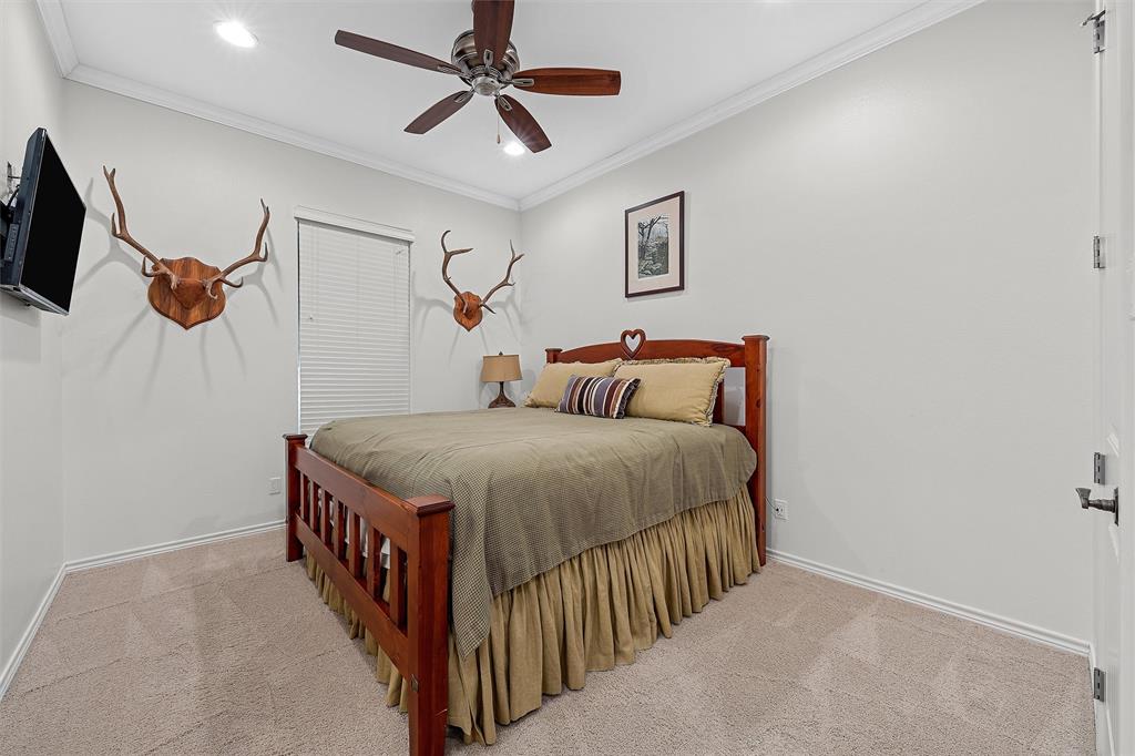 1170 Lumkins Road Forreston, TX 76041 - Photo 13 of 40 a bedroom with a bed a flat screen tv and a ceiling fan